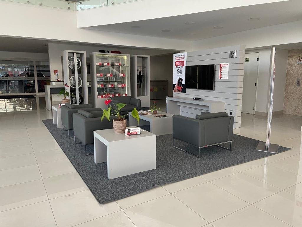Carpete cinza delimitando área de espera em showroom