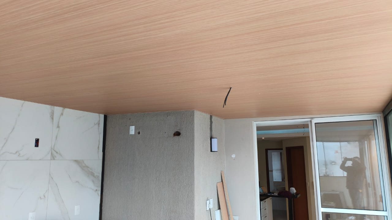 Teto vinílico amadeirado em sala com porta de vidro