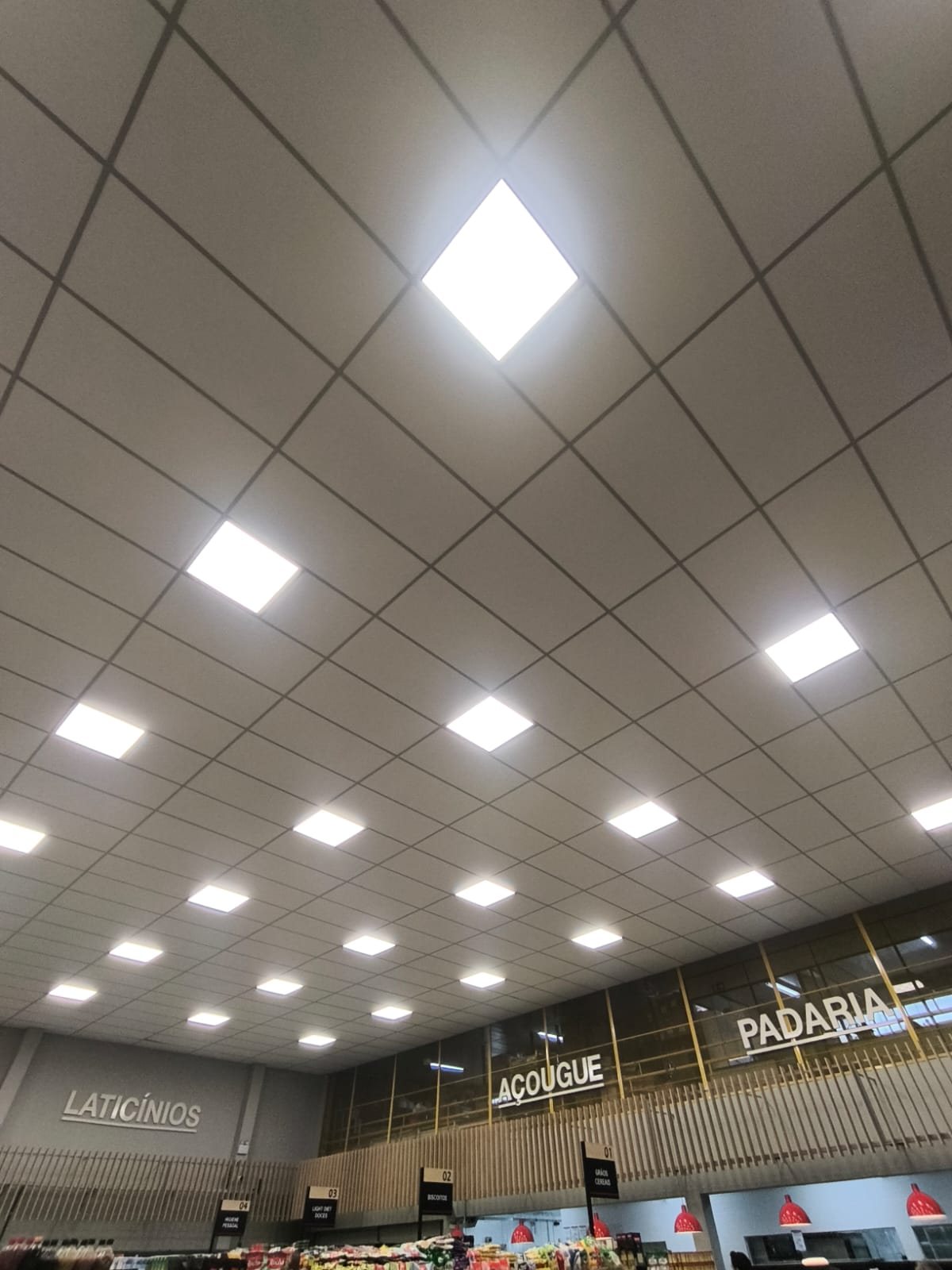 Forro modular branco com painéis de LED em supermercado