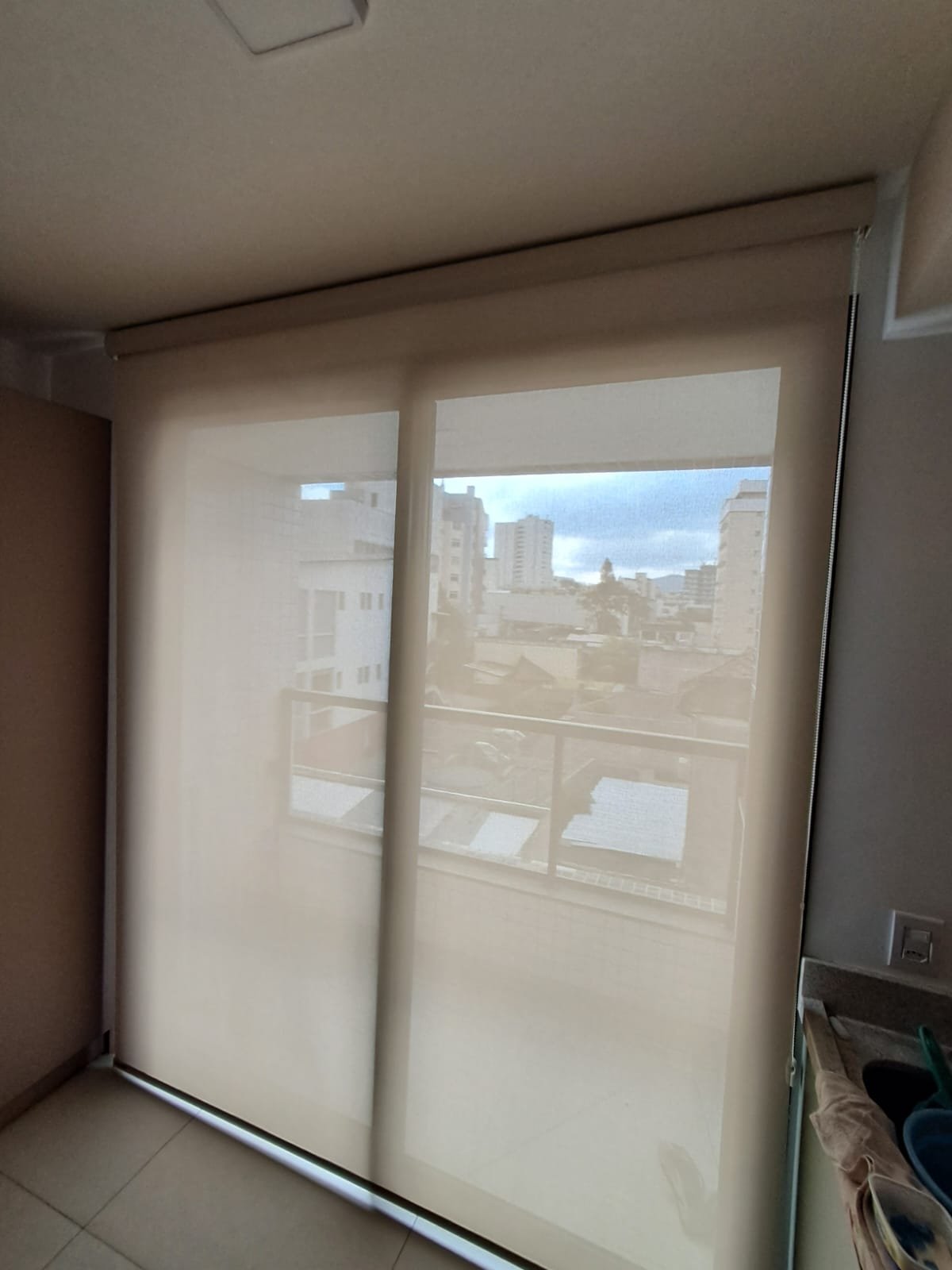 Persiana rolô sobre porta de sacada com vista
