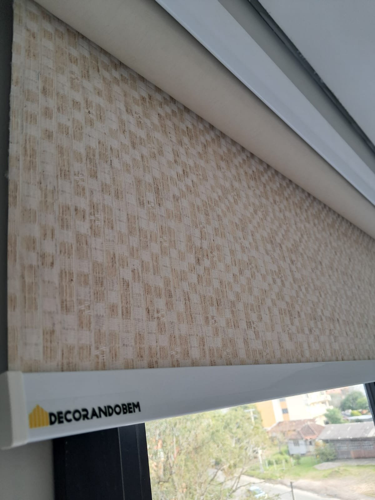 Detalhe do tecido de persiana rolô com etiqueta DecorandoBem