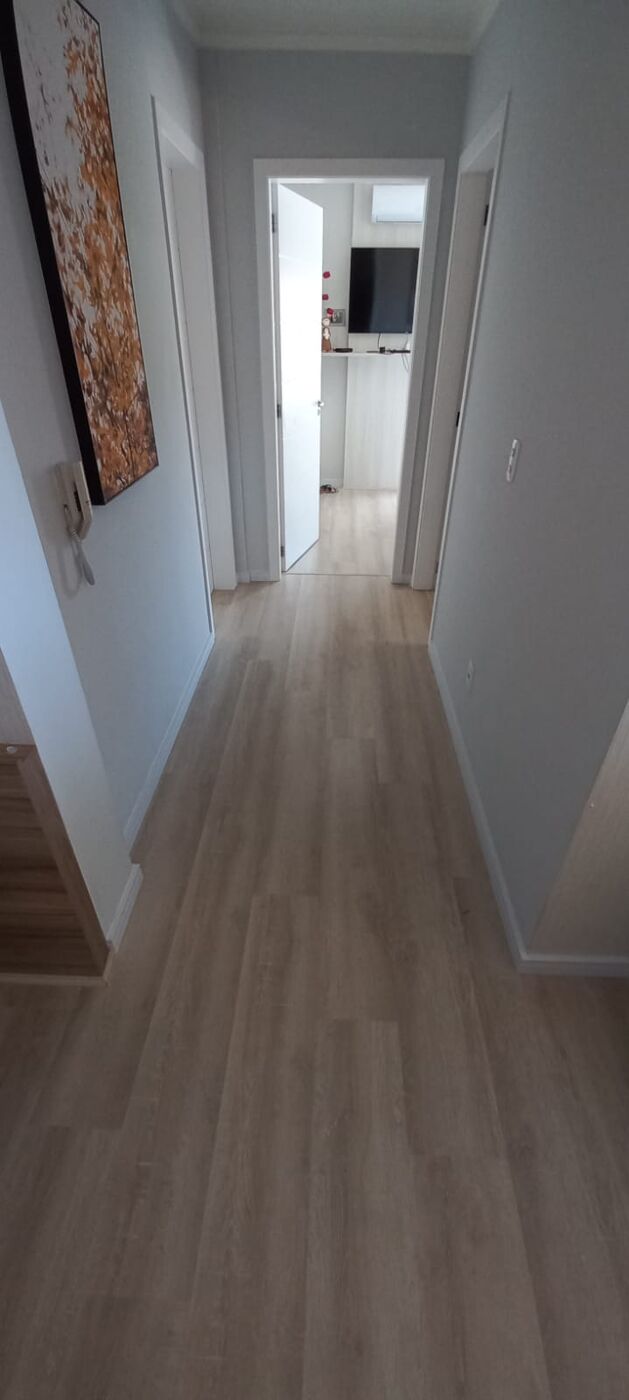 Piso laminado claro em corredor residencial