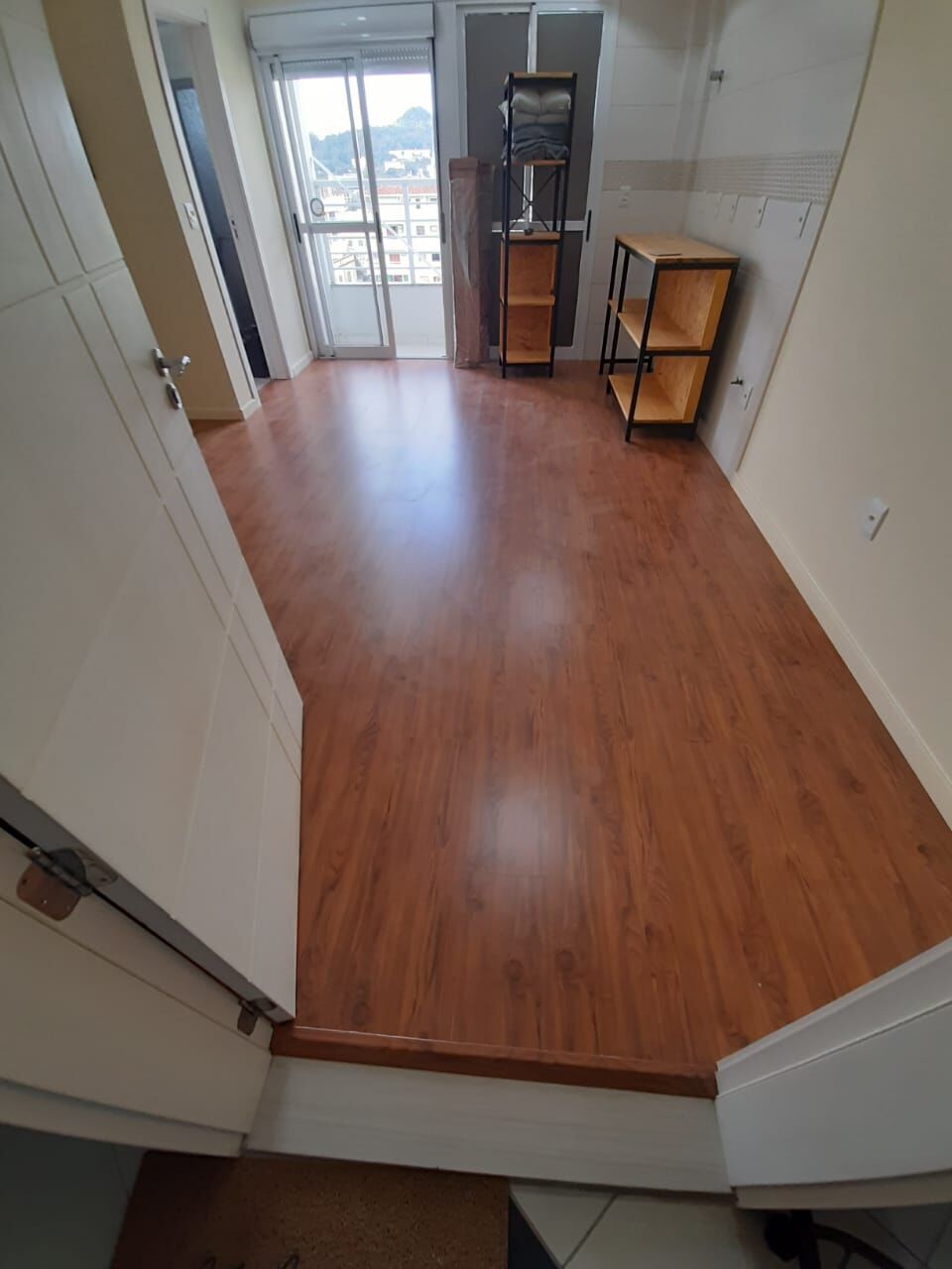 Piso laminado amadeirado em sala com rodapé