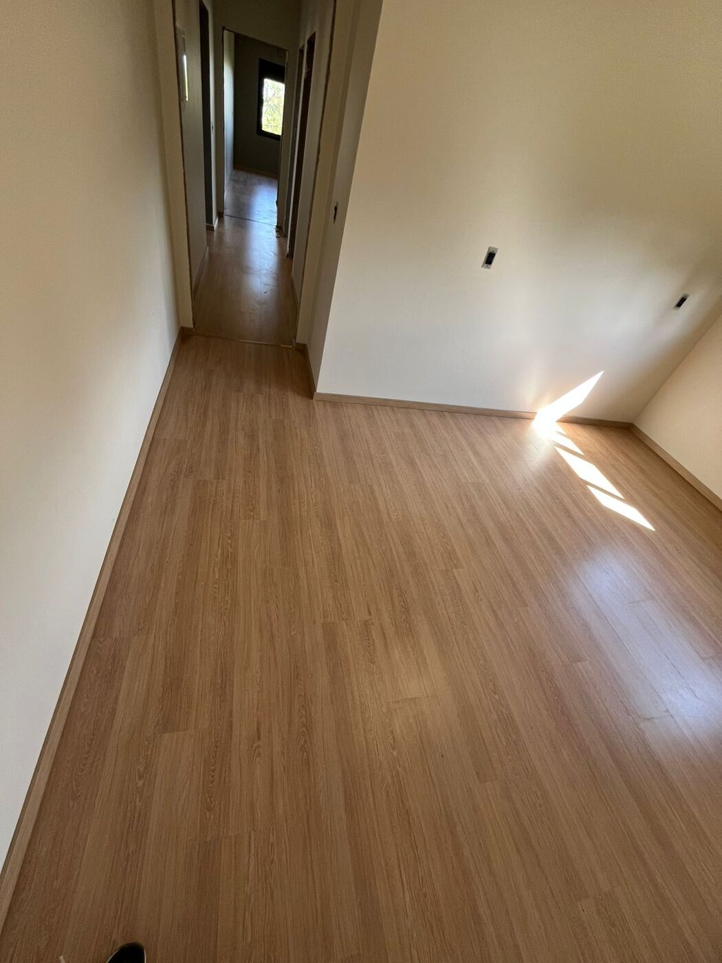 Piso laminado amadeirado em corredor iluminado