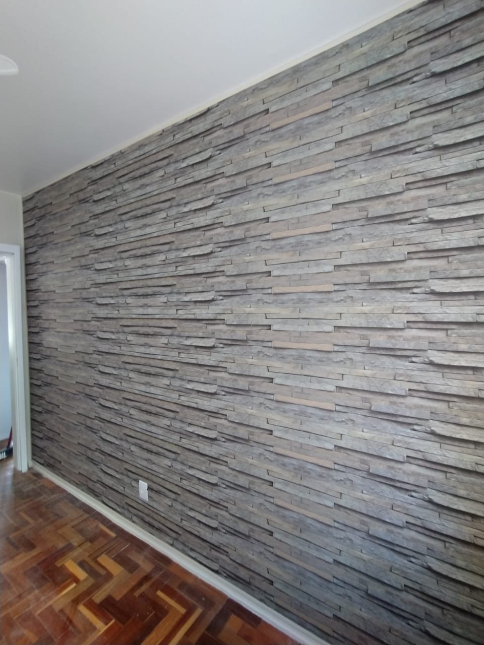 Revestimento de PVC efeito pedra em parede de sala