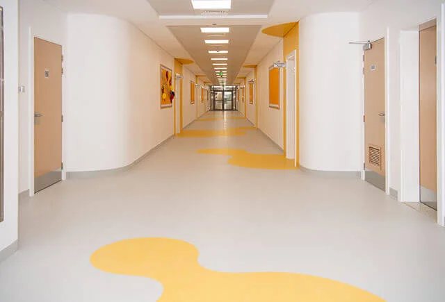 Manta homogênea em corredor de clínica — exemplo do modelo (Belgotex Palettone PUR)